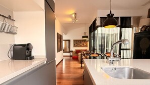 Cozinha moderna com ilha central, pia embutida e máquina de café.