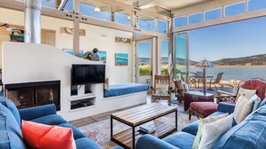 Amplia sala de estar con chimenea, asientos cómodos y un ventanal con vistas panorámicas.