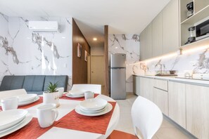 A modern kitchen with marble backsplash, a built-in fridge, and a dining area with a red placemat. - ¡Cerca de Fundidora! 7 huéspedes|King bed 2BR|2br (Monterrey)