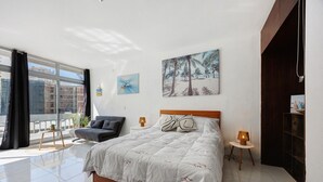 A bedroom with a large bed, a sofa, a small table, and a lamp. - Studio Apartment 'Ocean - Pet Frendly' with Balcony, Wi-Fi and Air Conditioning (Portimão)