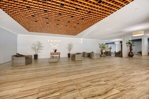 A spacious lobby with a wooden ceiling, a reception desk, wicker furniture, and a marble floor. - Studio Apartment 'Ocean - Pet Frendly' with Balcony, Wi-Fi and Air Conditioning (Portimão)