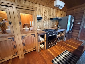 Eine Holzhütte mit einer Küche, inklusive Herd, Backofen und Kühlschrank.