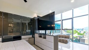 Une chambre moderne avec un grand lit, une télévision et une vue sur la ville.