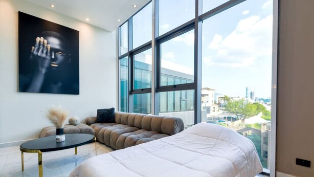 Une chambre moderne avec un grand lit, un canapé et une table basse ronde.