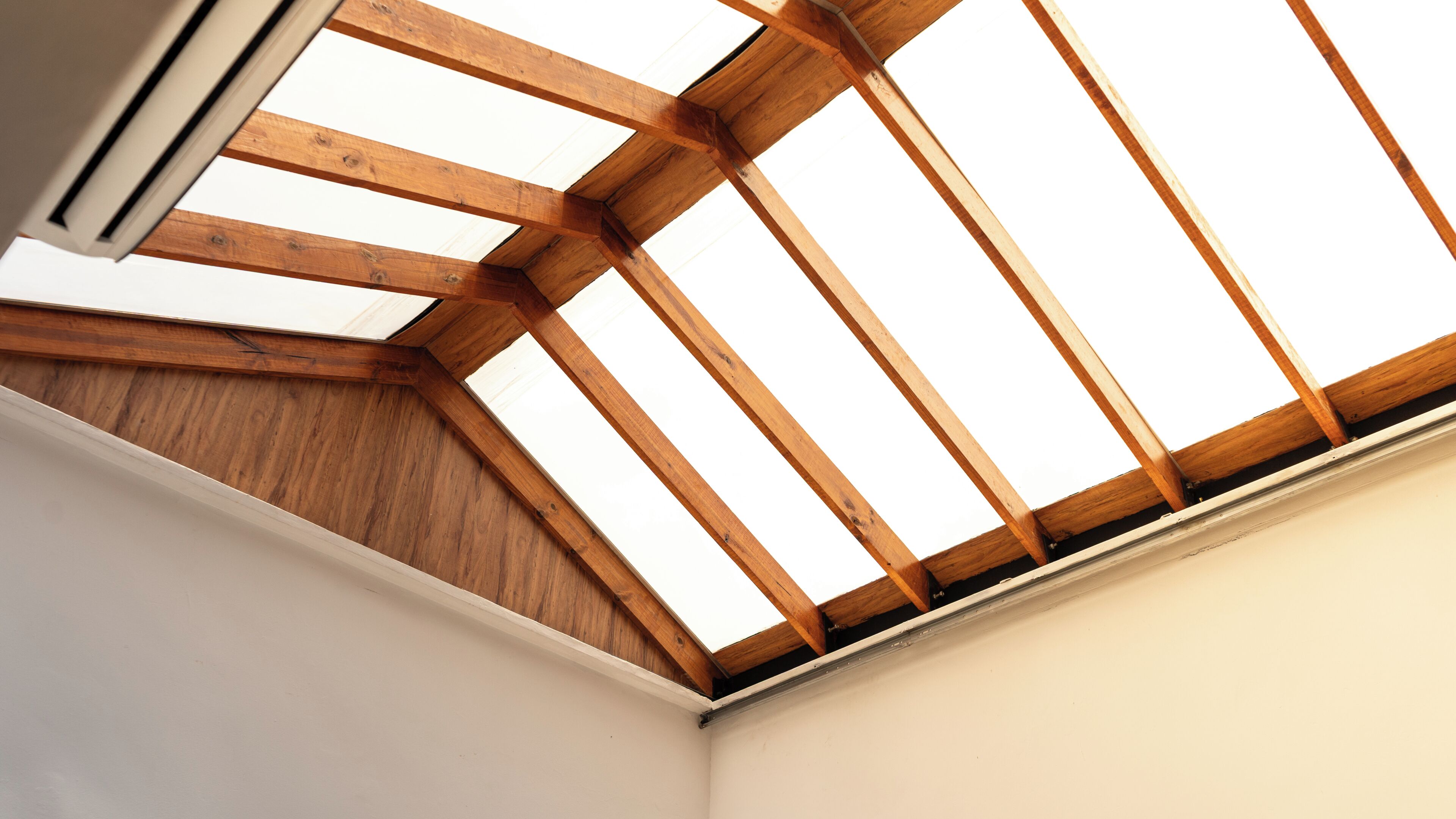 Ein Oberlicht mit Holzbalken und weißer Decke.