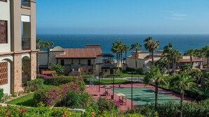 A resort with a tennis court, palm trees, and ocean views. - Cozy 1-bedroom resort in enchanting Cabo San Lucas with AC (Cabo San Lucas, B.C.S.)