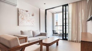 A modern living room with a sofa, coffee table, and a painting on the wall. - Majestic 1-Bed Balcony City View Suite by Bocobay (Willemstad)