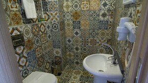 Een badkamer met toilet, wastafel en betegelde muren.