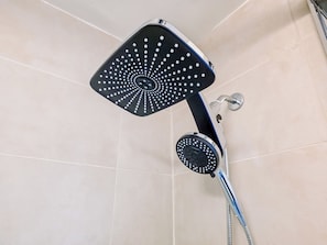 A shower with a square head and a round head, both with multiple holes, installed in a tiled bathroom. - Sanctum / King Bed / Elevator / Adjustable Desk (Philadelphia)