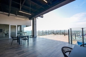 A modern office space with a panoramic city view, featuring a glass partition, a meeting table, and contemporary chairs.