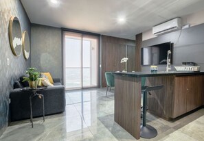 Een moderne keuken met een centraal eiland, barstoelen en een inbouwoven.