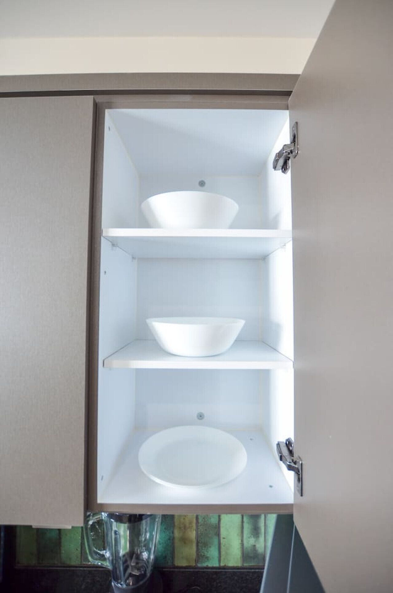 A bathroom with a white sink, a mirror, and a shelf.