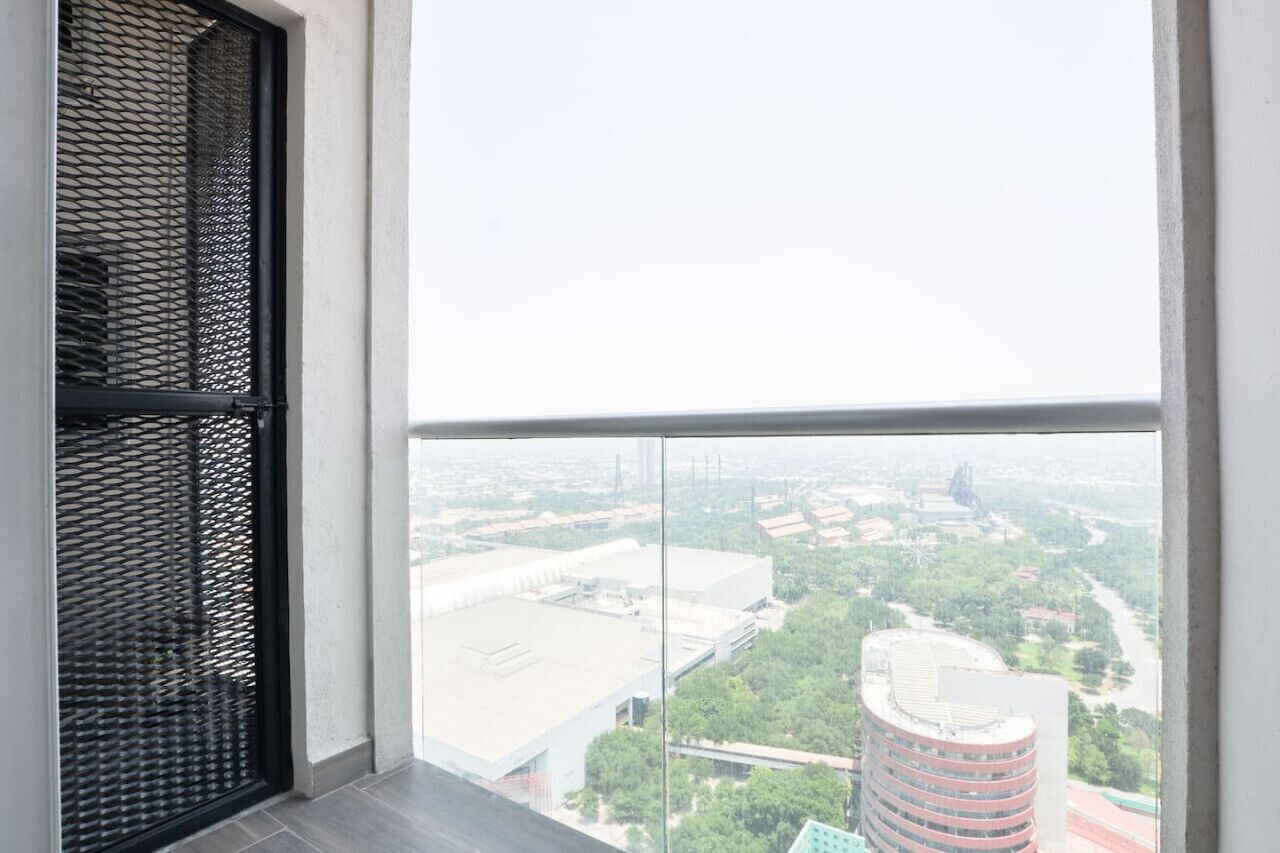 A high-rise building with a large window overlooking a cityscape.