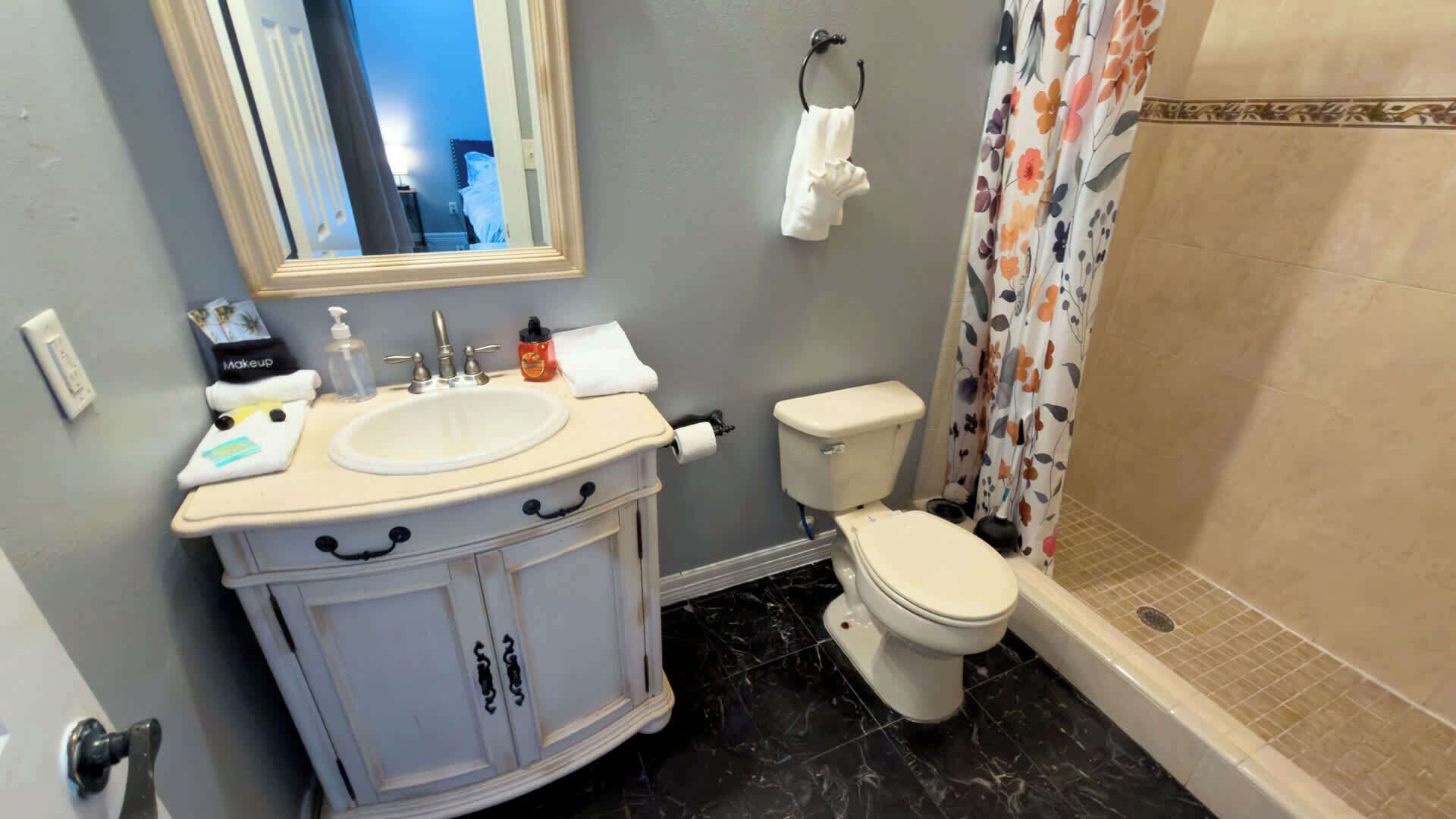 Un baño con lavamanos, inodoro y ducha.