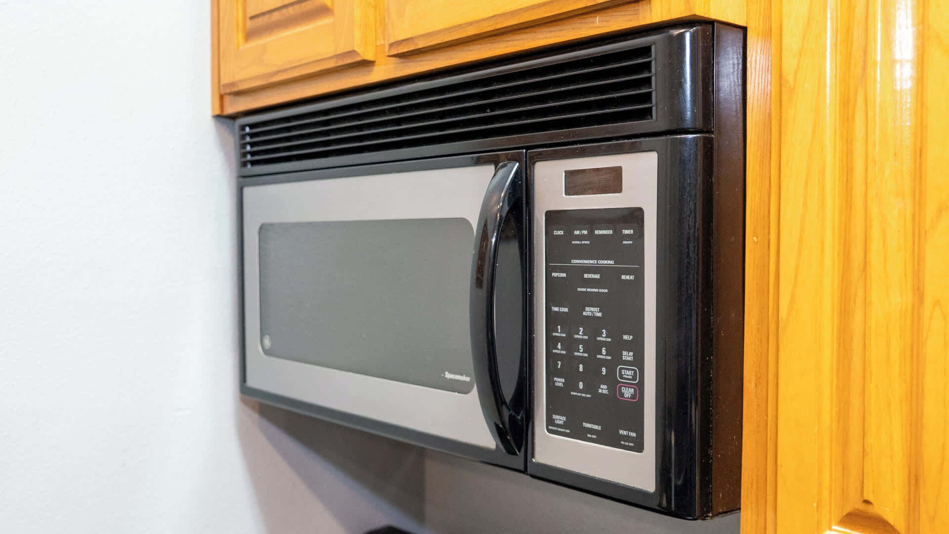 Un four à micro-ondes doté d’un panneau de commande numérique, d’une grille d’aération et d’un bouton d’alimentation.