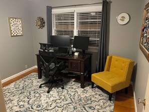 A home office with a desk, two monitors, a chair, and a yellow armchair. - KC World Cup Hot Tub, Outdoor TVs, Gym, 15 Min to Stadium. (Kansas City)