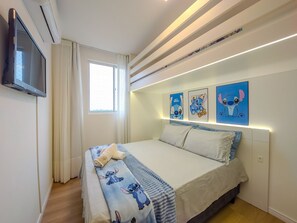 A bedroom with a bed, a TV, and three wall-mounted pictures. - Curta Praia do Quilombo - Lunata (Penha)