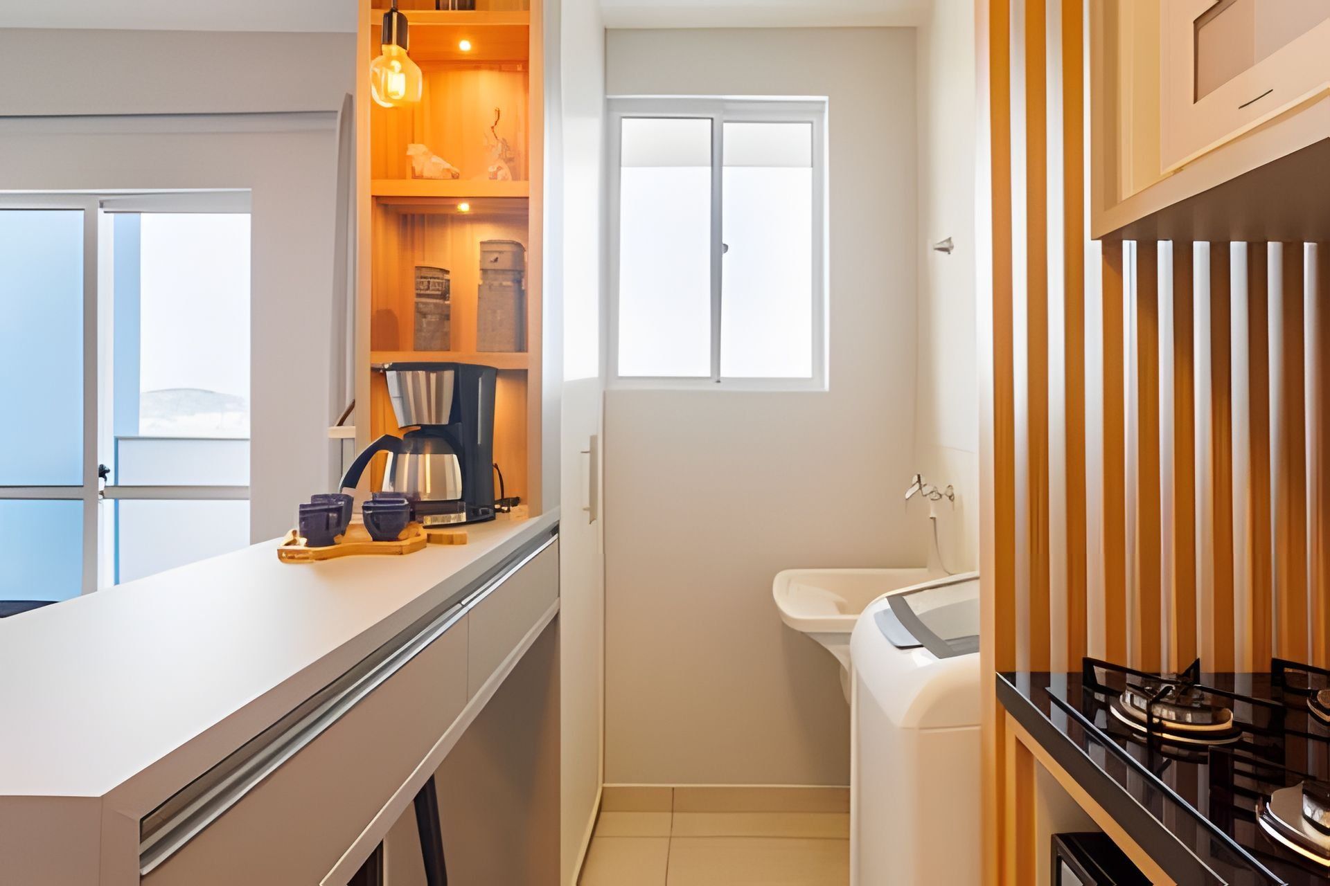 Una cocina compacta con cafetera, lavabo y ventana.