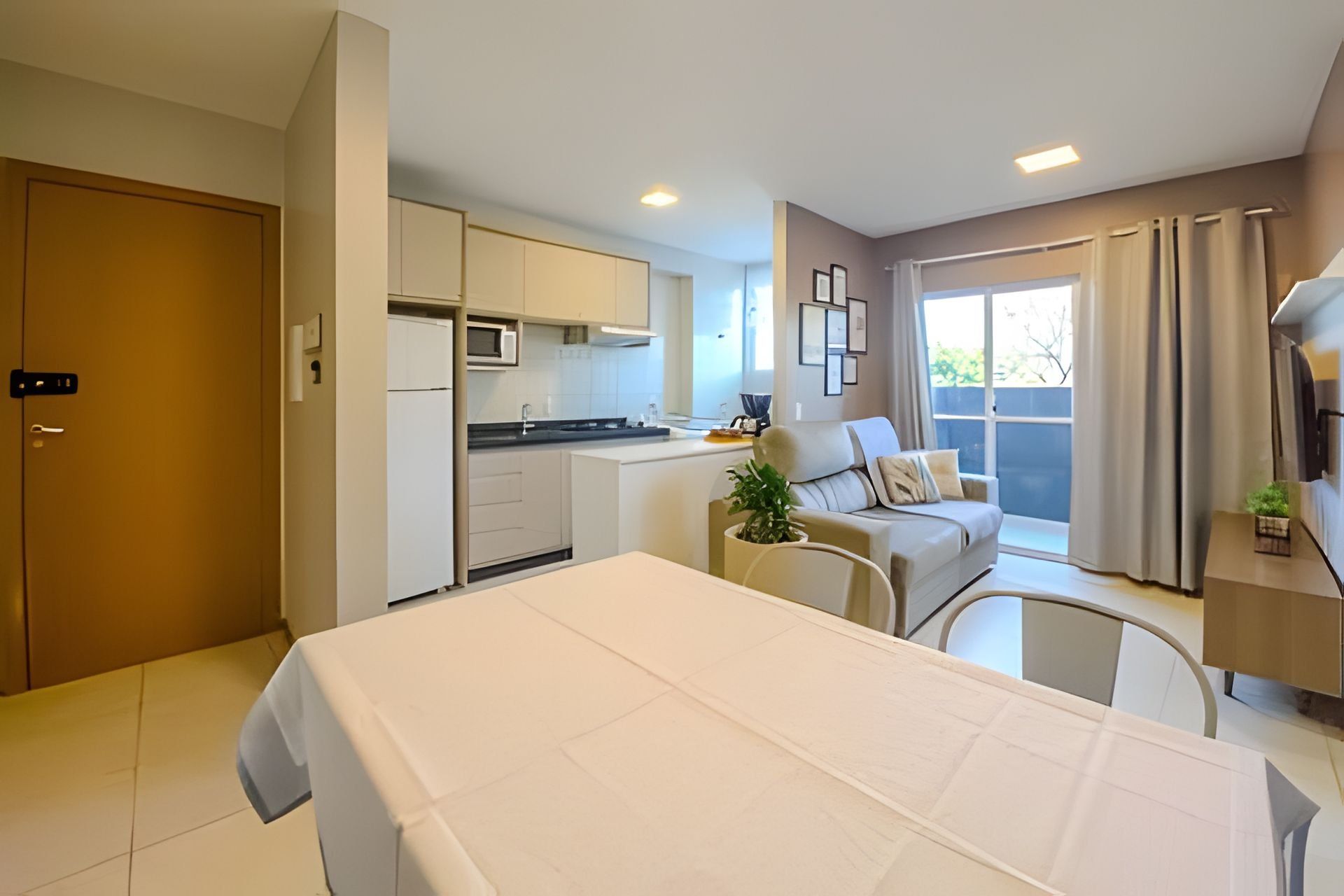Quarto de hotel compacto com cama, cozinha compacta e área de estar com vista.