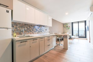 A modern kitchen with a large island, white cabinetry, and a hexagonal tile backsplash. - Zona Purísima y CAS - ¡5 camas, GYM y alberca! (Monterrey)
