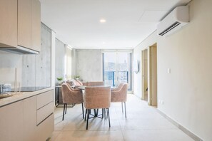 Eine moderne Küche mit Essbereich, großen Fenstern und Blick auf die Stadt.