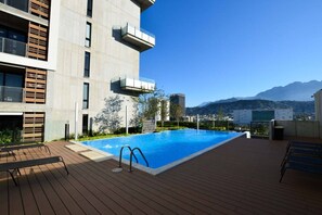 A rooftop pool with a clear view of mountains, surrounded by a modern building with balconies. - Luxury in La Purísima! / CAS / 1 person (Monterrey)