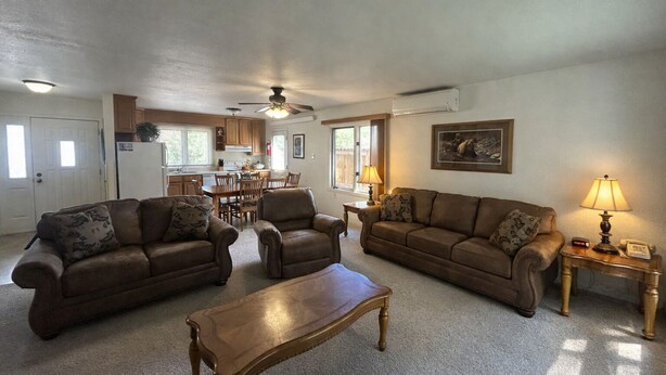 A living room with two sofas, a coffee table, and a dining area with a table and chairs. - Rocky Cliff 3 bedroom/2 bath home located in the town of Hill City! (Hill City)