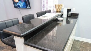 A conference room with a long black table, four black chairs, a whiteboard, and a television on the wall. - Steps to the Beach Great Value Pool Home (South Padre Island)