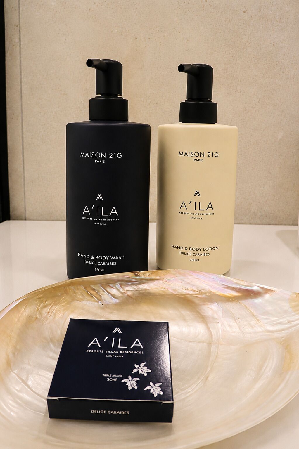 Two bottles of hand and body wash and a box of triple milled soap on a table.