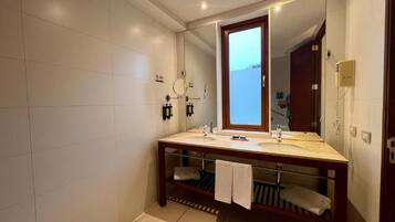 Un baño moderno con dos lavamanos, un espejo grande y un perchero para toallas.