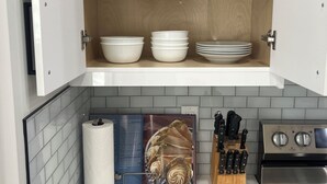 A kitchen with white cabinets, a marble countertop, and a stainless steel stove.