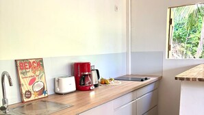 Una cocina con encimera de madera, cafetera, tostadora y fregadero.