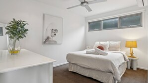 A bedroom with a bed, bedside table, lamp, and a painting on the wall. - Serena House  Luxury Fingal Retreat with Views (Fingal)