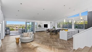 A spacious modern kitchen with a large island, a dining area, and a view of the outdoors. - Serena House  Luxury Fingal Retreat with Views (Fingal)