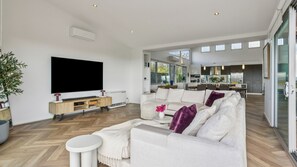 Ein modernes Wohnzimmer mit Flachbildfernseher, einer Couch und einem Couchtisch.
