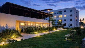 A modern hotel with a covered outdoor area and a well-lit pathway. - Apto Porto de Galinhas (Ipojuca)