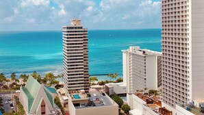 A high-rise hotel with a view of the ocean, multiple balconies, and a pool area. - Waikiki Banyan Ocean View Suite, High Floor Remodeled, AC & Free Parking (Honolulu)