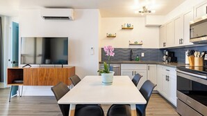 A modern kitchen with a dining area, built-in appliances, and decorative shelves. - Waikiki Banyan Ocean View Suite, High Floor Remodeled, AC & Free Parking (Honolulu)