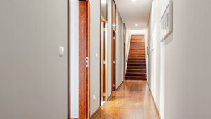 A modern hallway with wooden flooring and white walls, leading to a staircase. - Casa Keam is a peaceful private retreat set in the hills of Santana (Santana)