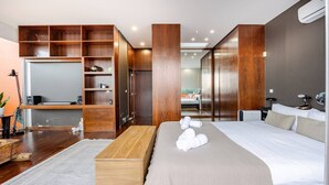 A modern hotel room with a large bed, a wooden desk, a built-in wardrobe, and a bathroom visible through an open door. - Casa Keam is a peaceful private retreat set in the hills of Santana (Santana)