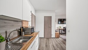 Een moderne keuken met een houten aanrecht, een roestvrijstalen spoelbak en een magnetron.