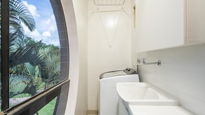 A bathroom with a window, a washing machine, and a bathtub. - Complete Apartments in Asa Norte - BSB BVT (Brasília)