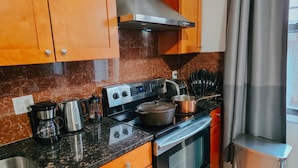 Une cuisine équipée d’une cuisinière en acier inoxydable, d’une machine à café, d’un grille-pain et d’une casserole sur la plaque de cuisson.