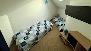A small, compact room with two single beds, a desk, a chair, and a ceiling light. - House just a stone's throw from the sea (Saint-Gilles-Croix-de-Vie)