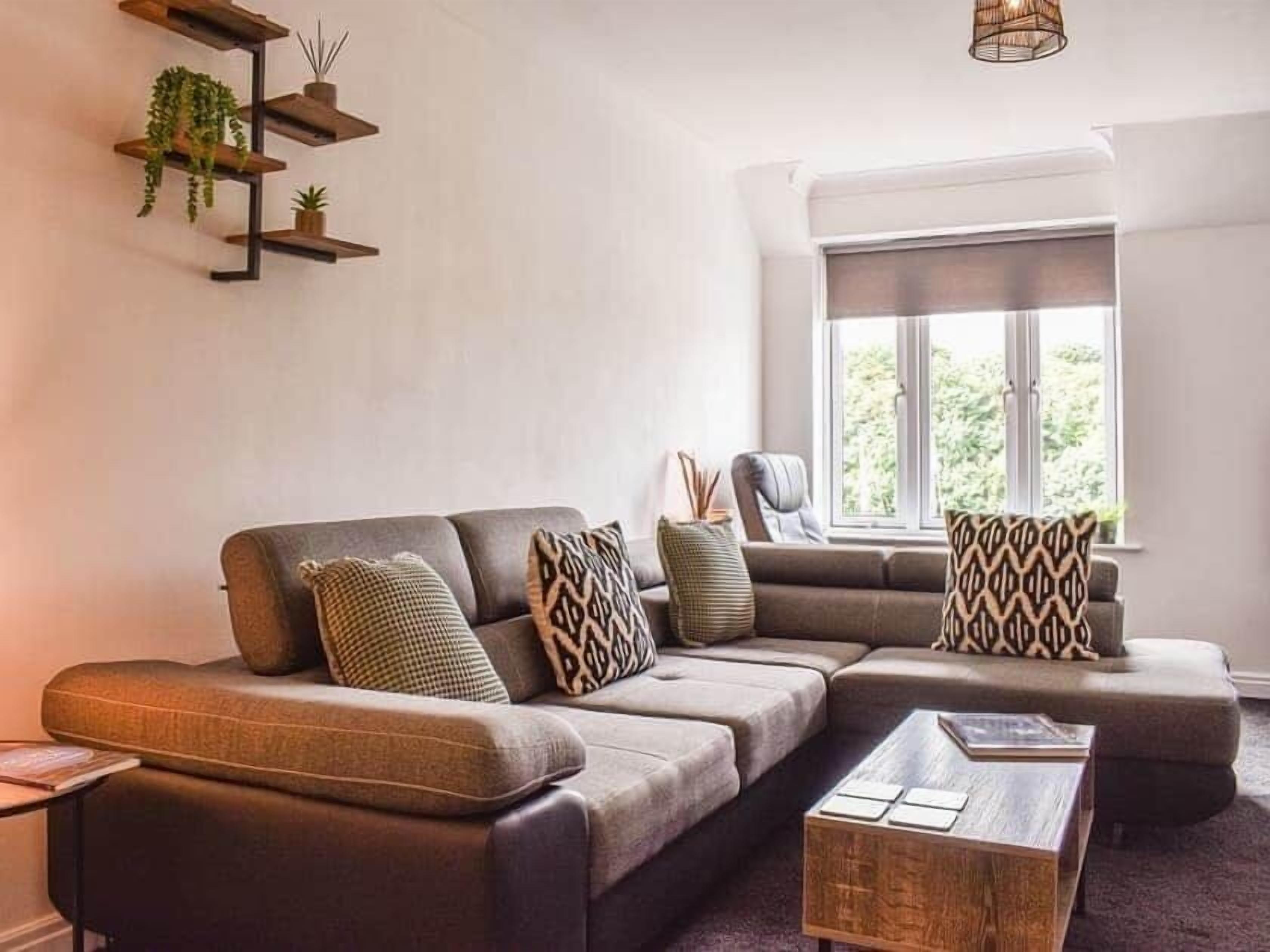 Ein modernes Wohnzimmer mit einem Ecksofa, einem Couchtisch und einem Fenster mit Blick.