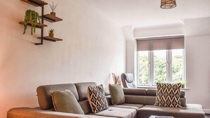 Uma sala de estar moderna com um sofá seccional, uma mesa de centro e uma janela com vista.