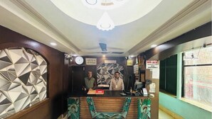 A reception desk with a clock, a sign for 'Hotel Jay', and a reception area. - Hotel Jay Deluxe (Sasaram)