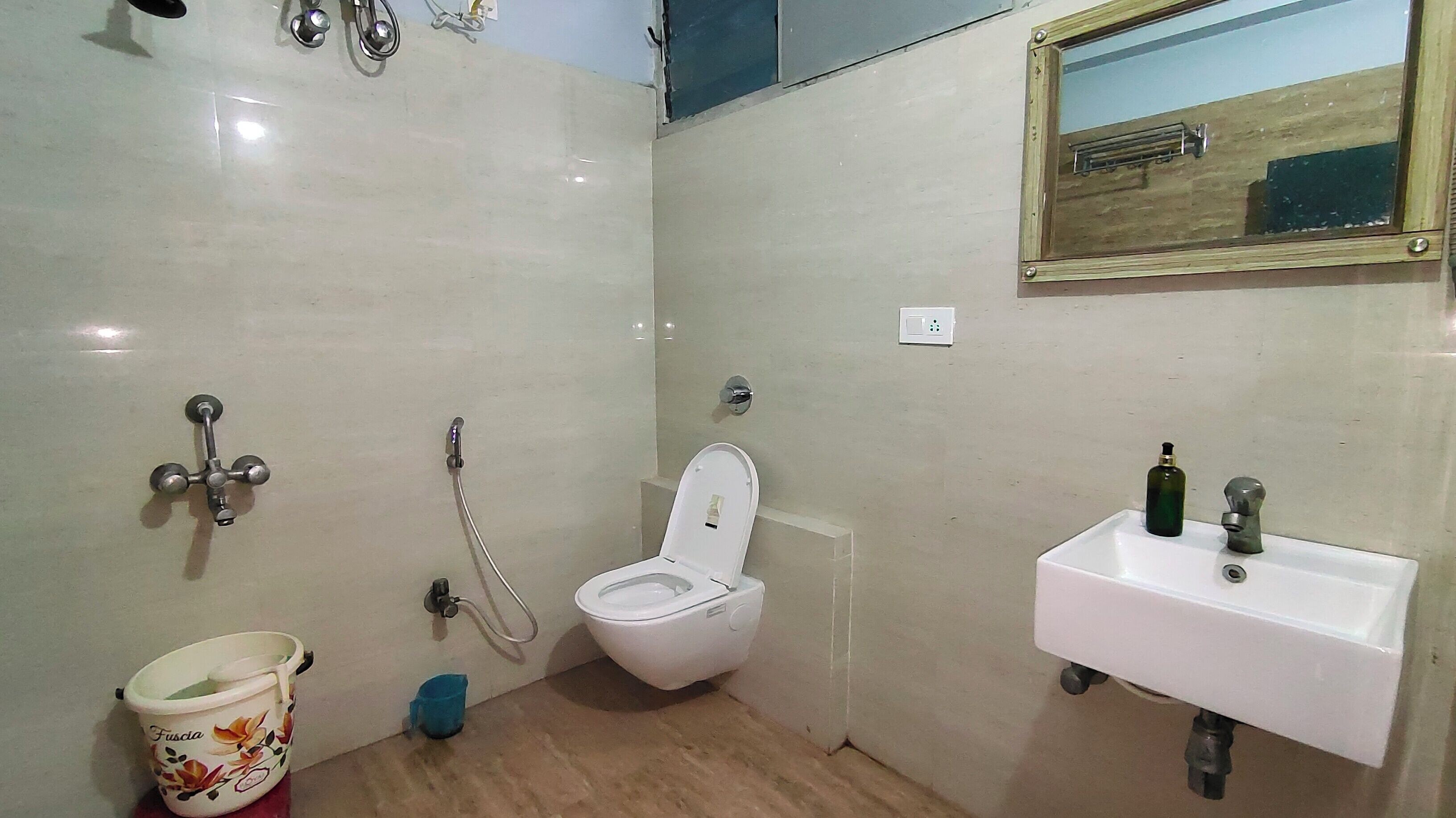 A small, compact bathroom with a toilet, sink, and shower.