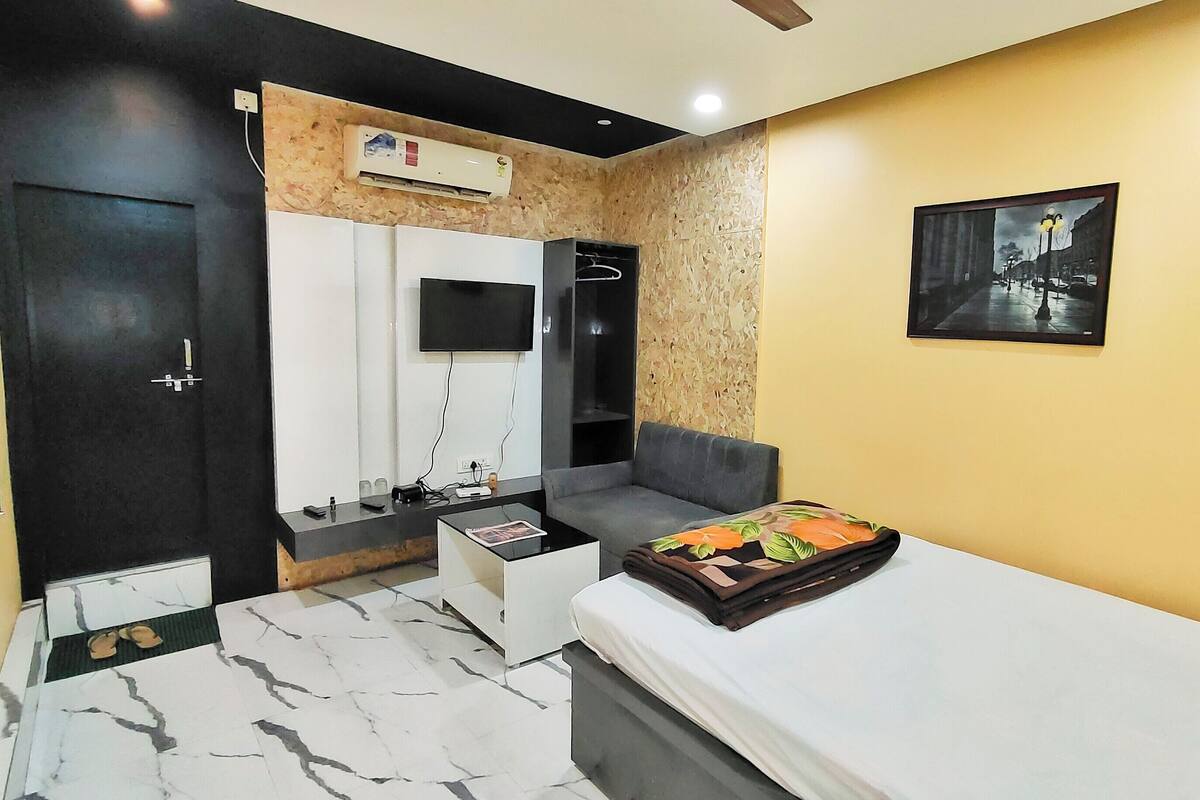Ein modernes Schlafzimmer mit Bett, Fernseher, Kleiderschrank und Bad.