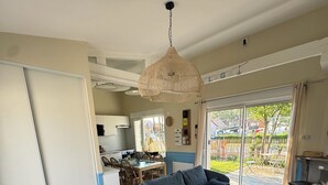 A modern living room with a blue sofa, a wooden coffee table, and a hanging woven light fixture. - Villa les dunes (Merlimont)